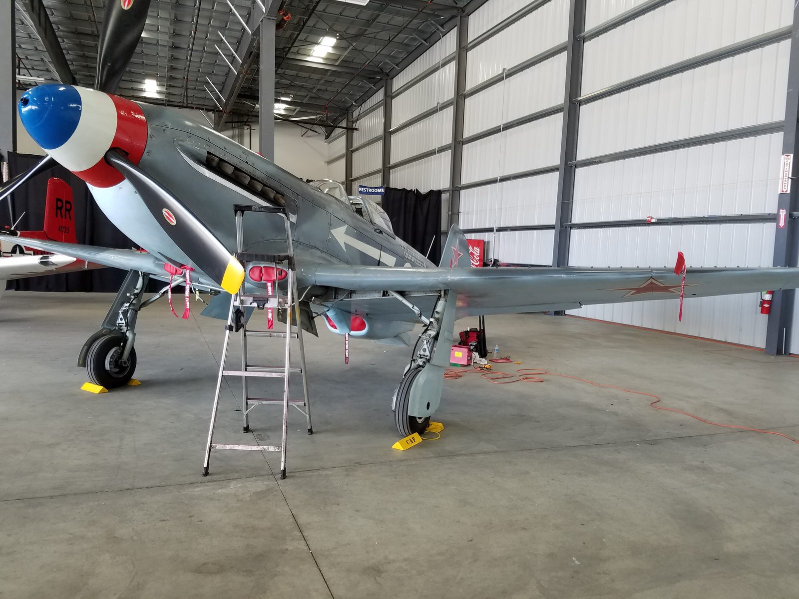 A Yakovlev warbird undergoing maintenance in a hangar